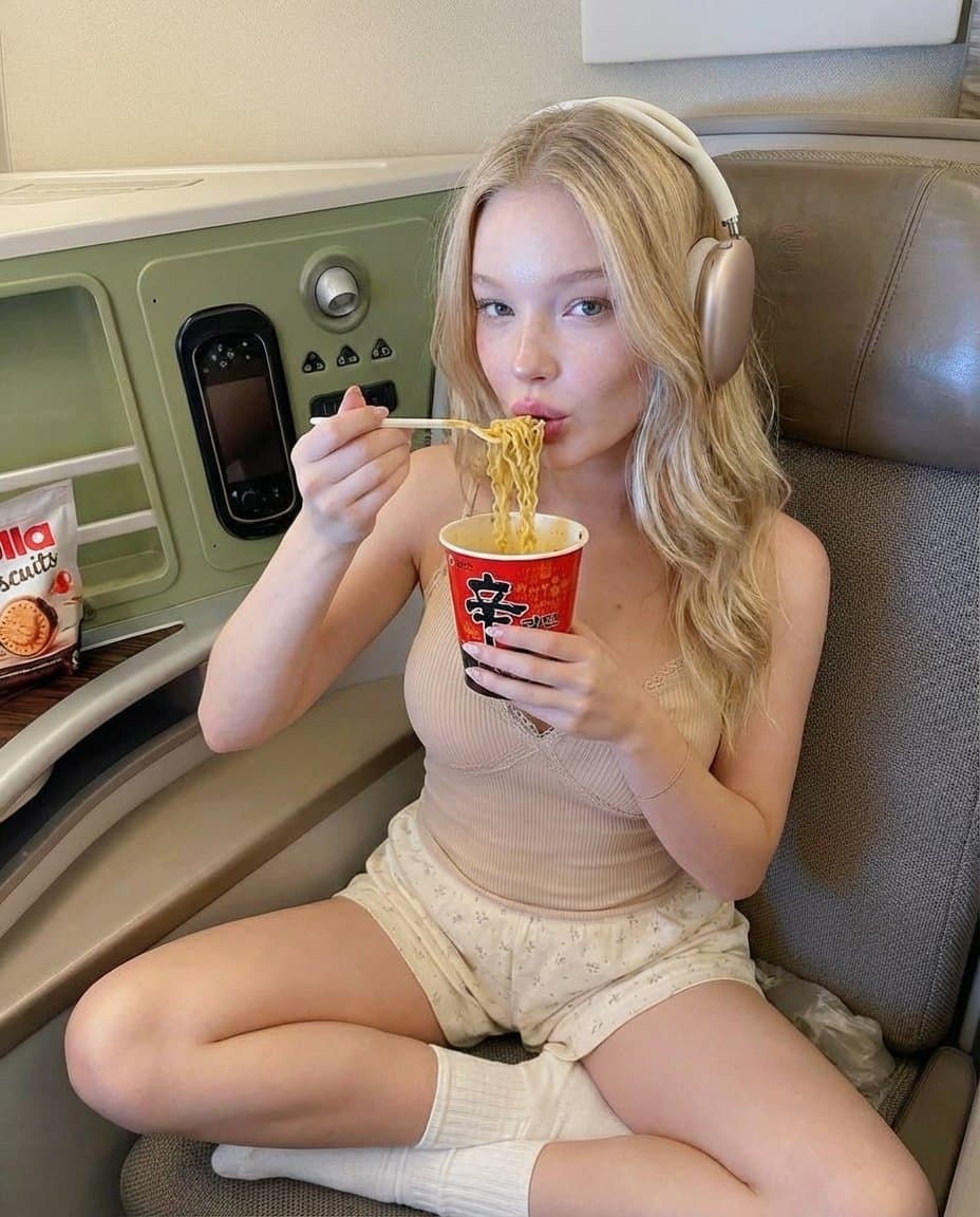 Woman Eating Noodles in Premium Travel Cabin