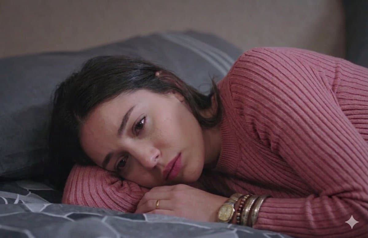 Somber Woman in Pink Turtleneck on Bed